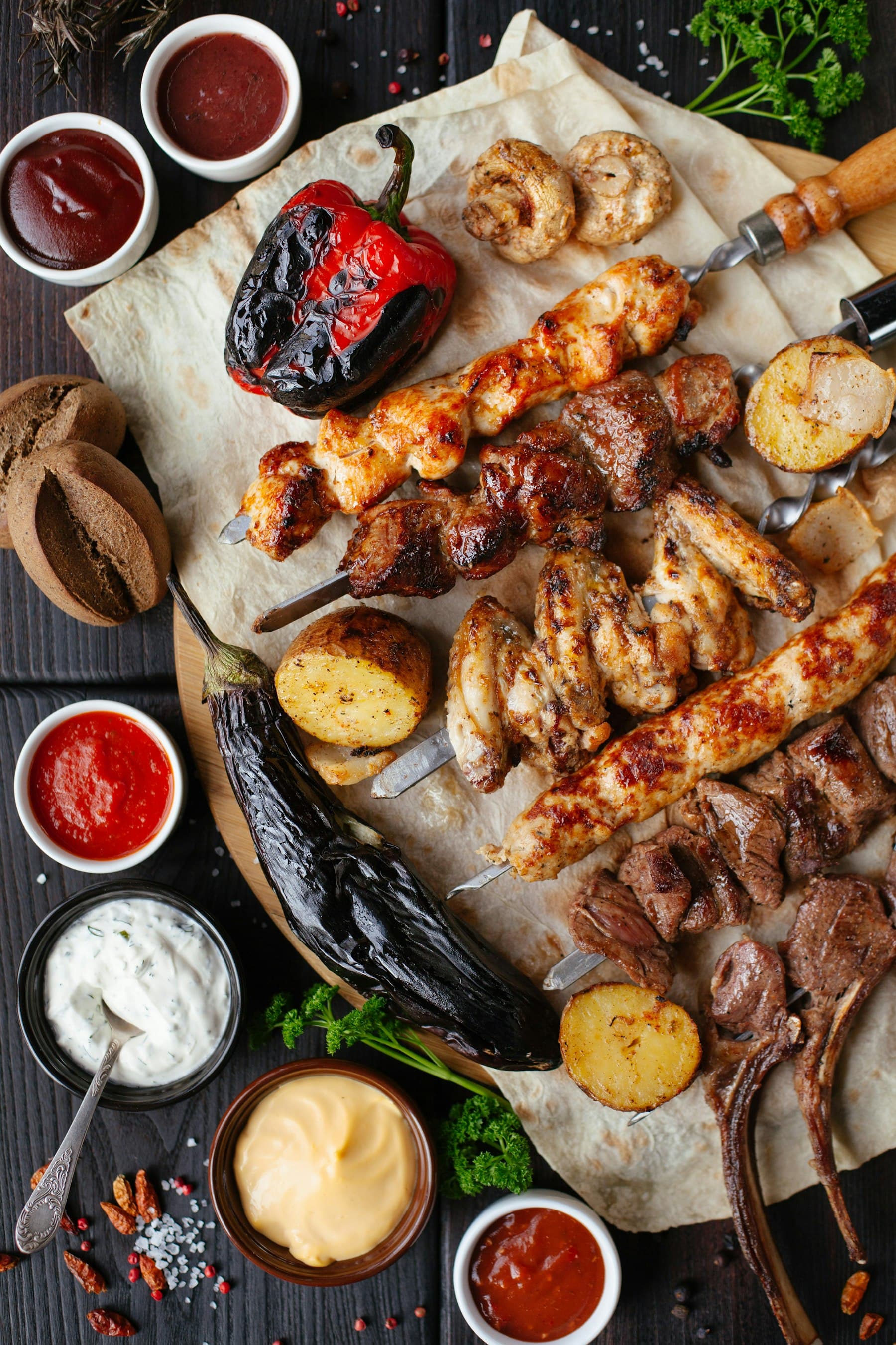 A shared platter of grilled meat, bread, and sauces — the kind of table that belongs to a southern evening